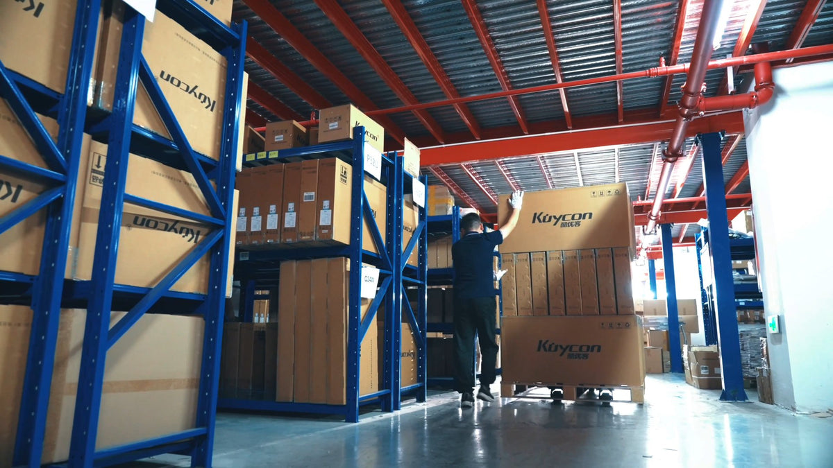 Warehouse staff handling KUYCON monitor cartons